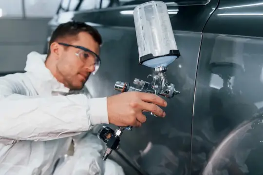 Experto pintando la puerta de un coche