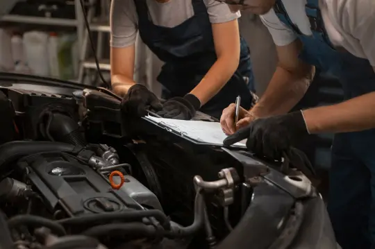 Técnicos revisando el motor de un coche