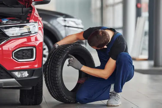 Mecánico revisando una rueda en el taller de coches